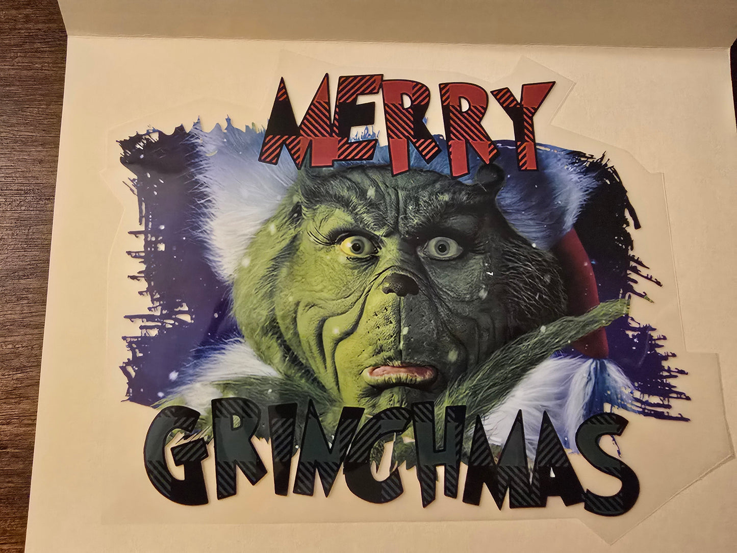 Card with a Grinch face and 'Merry Grinchmas' text on a plain background