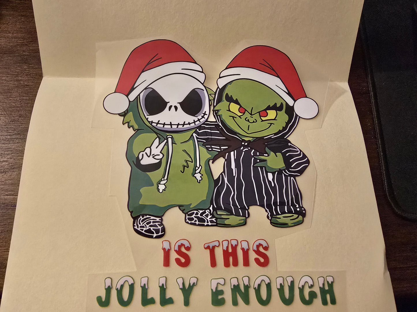 Cartoon characters in Christmas hats with text 'IS THIS JOLLY ENOUGH' on a beige background